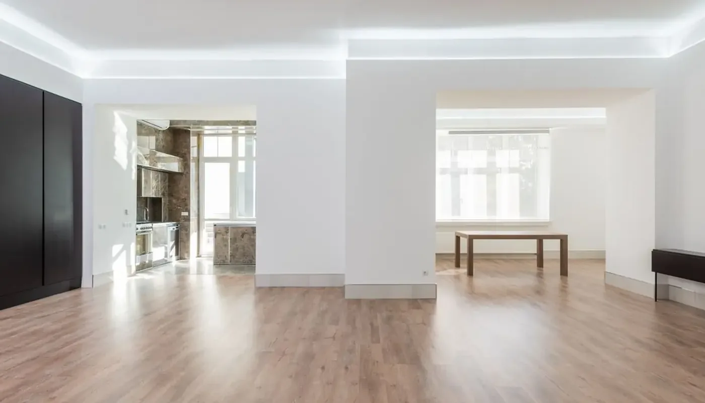 An empty unfurnished flat with pale walls and wooden flooring, the condition a check-out report has to record at the end of a tenancy